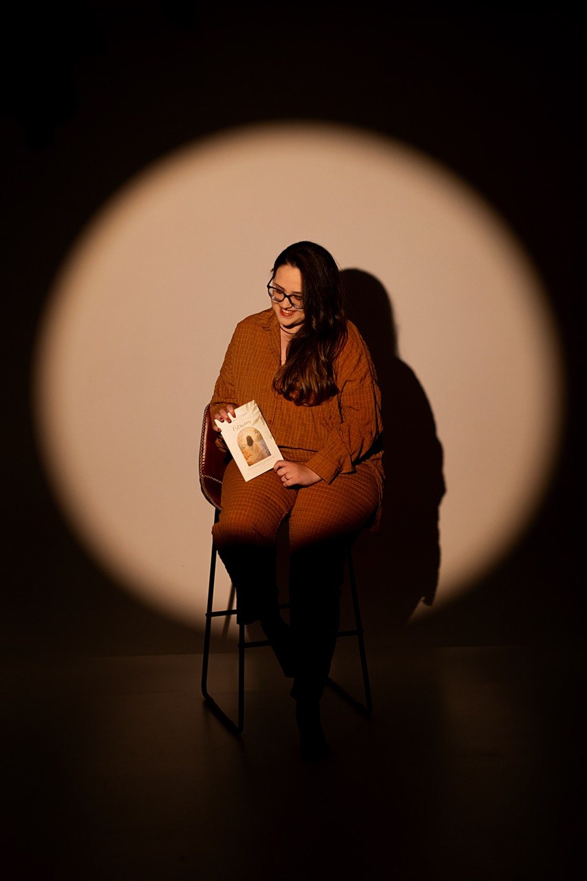 Luísa Costa Jesus em retrato, segurando o livro O Desfrute das Estações.